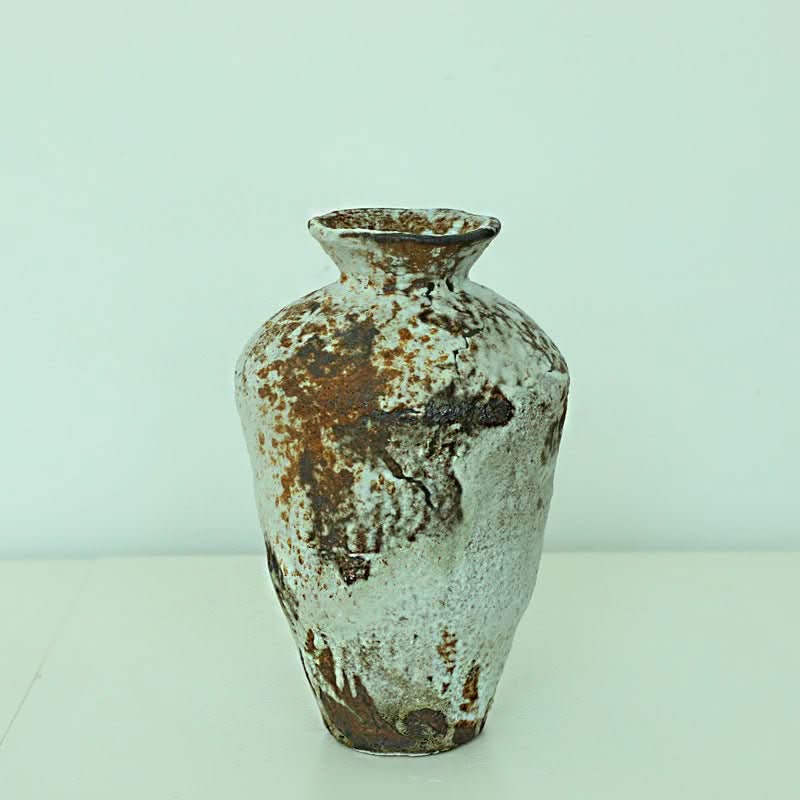 Rustic handmade ceramic vase, Wabi-Sabi style, with rugged texture in white and brown.