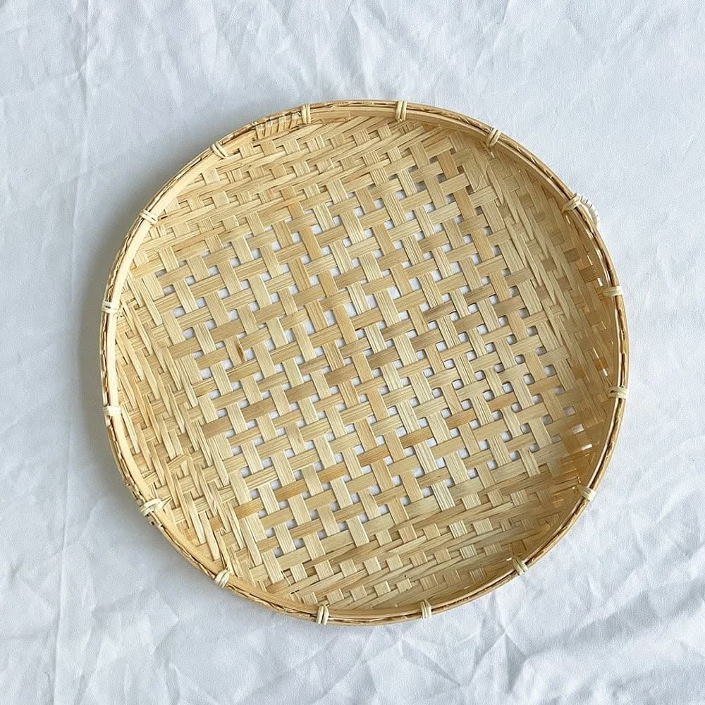 Handmade natural rattan wall hanging decor, round woven basket detail on white background.