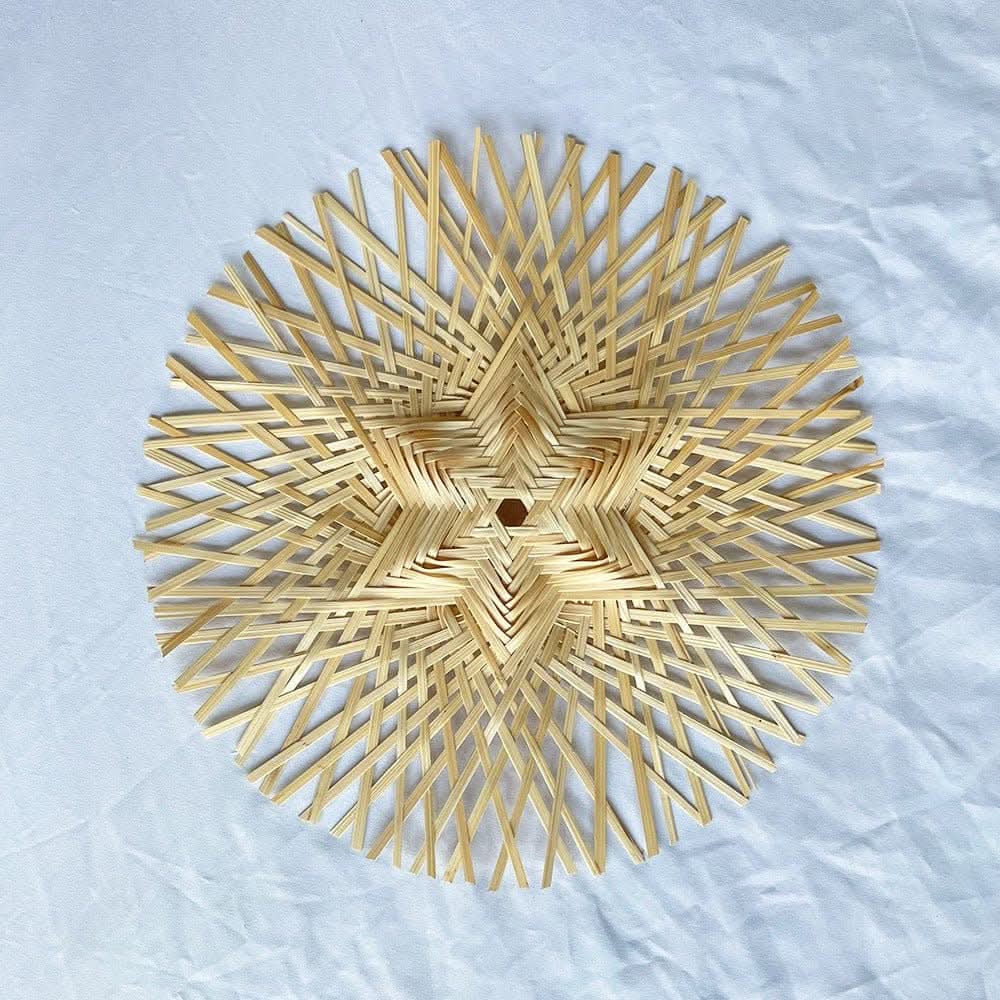 Natural rattan wall hanging handmade set with starburst design on white fabric background.