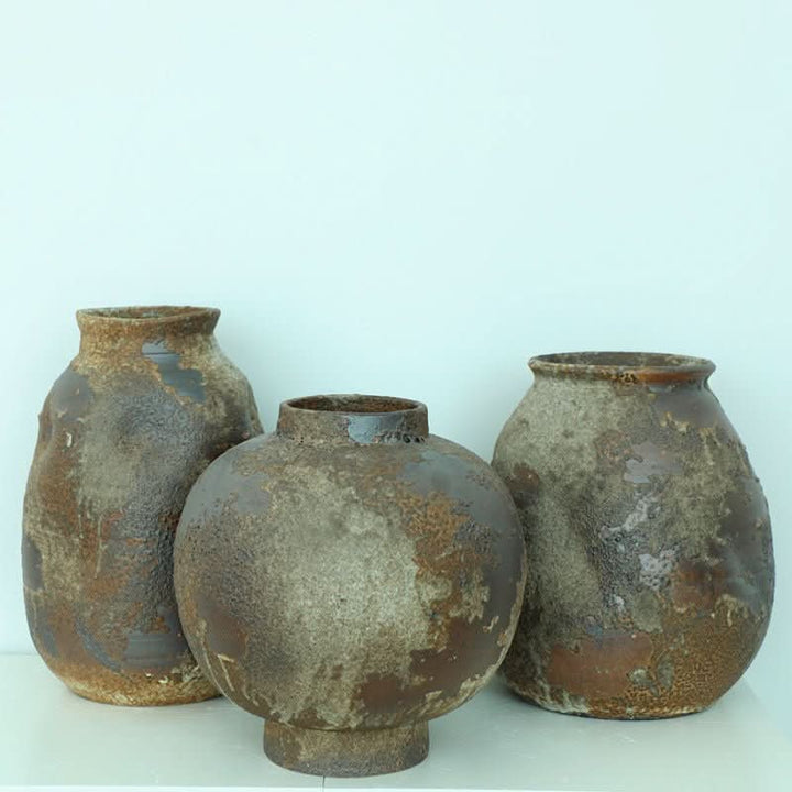 Handmade stoneware vases, rustic brown, irregular shapes, flower arrangement.