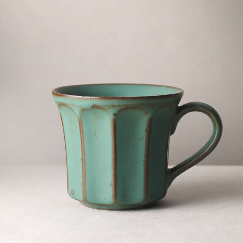 Teal handmade stoneware coffee mug with vertical pattern, rustic Nordic Japanese style.