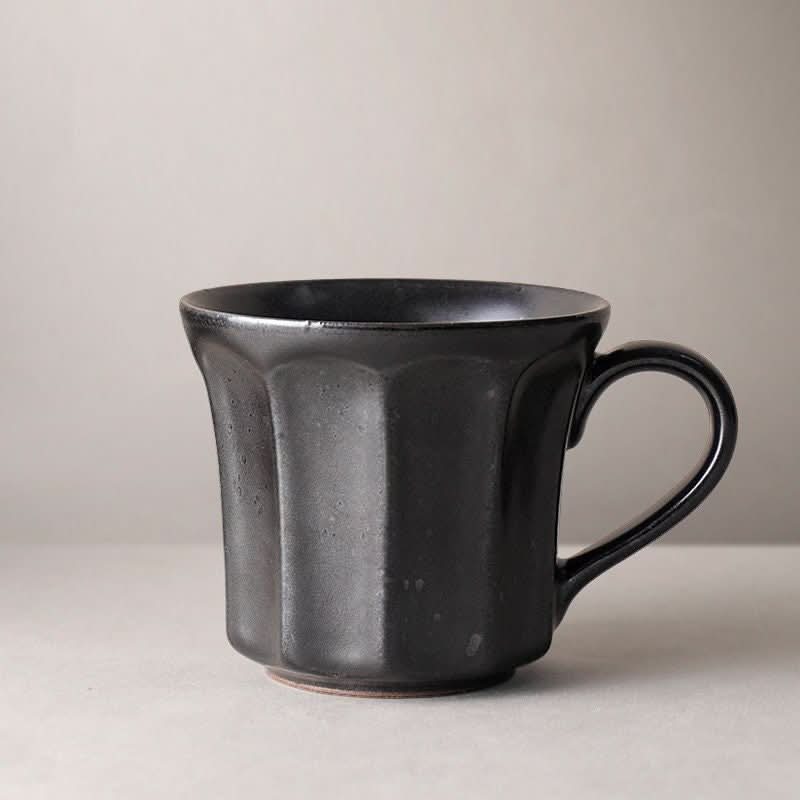 Black speckled stoneware coffee mug with vertical pattern. Nordic, Japanese, rustic.