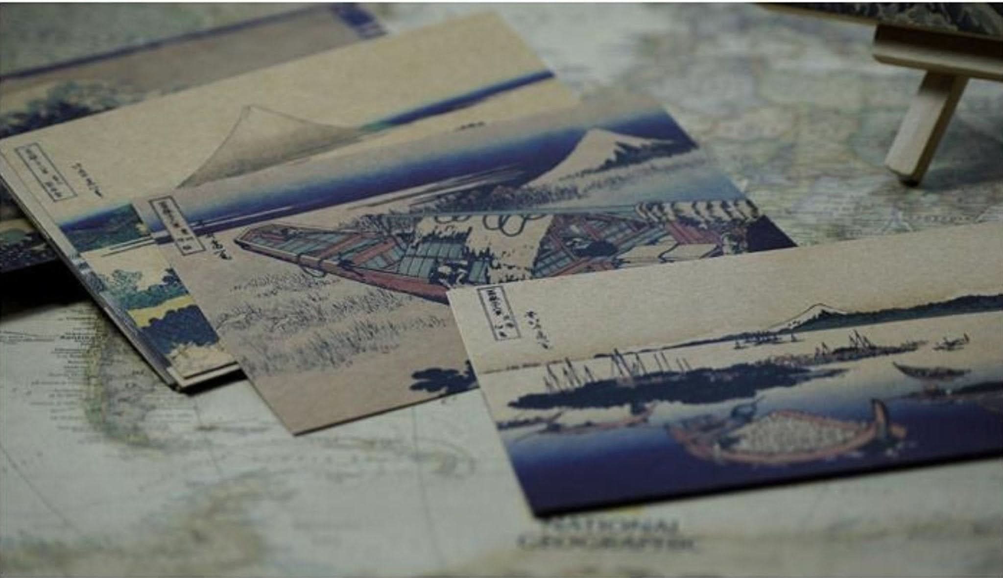 Hokusai Japanese Art Postcards with Ukiyo-E scenes, featuring boats and mountains.