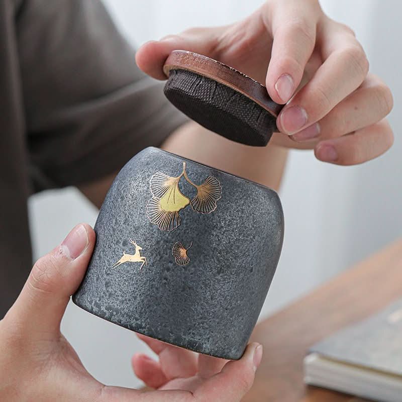 Gray stoneware tea caddy with gold deer and ginkgo design, airtight kitchen storage.