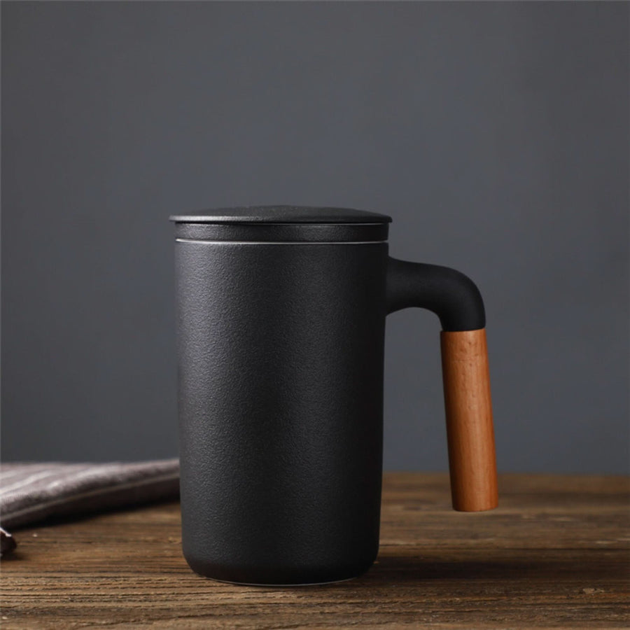 Black ceramic Japanese Mug 2x1 with lid, strainer, and wooden handle on rustic table.