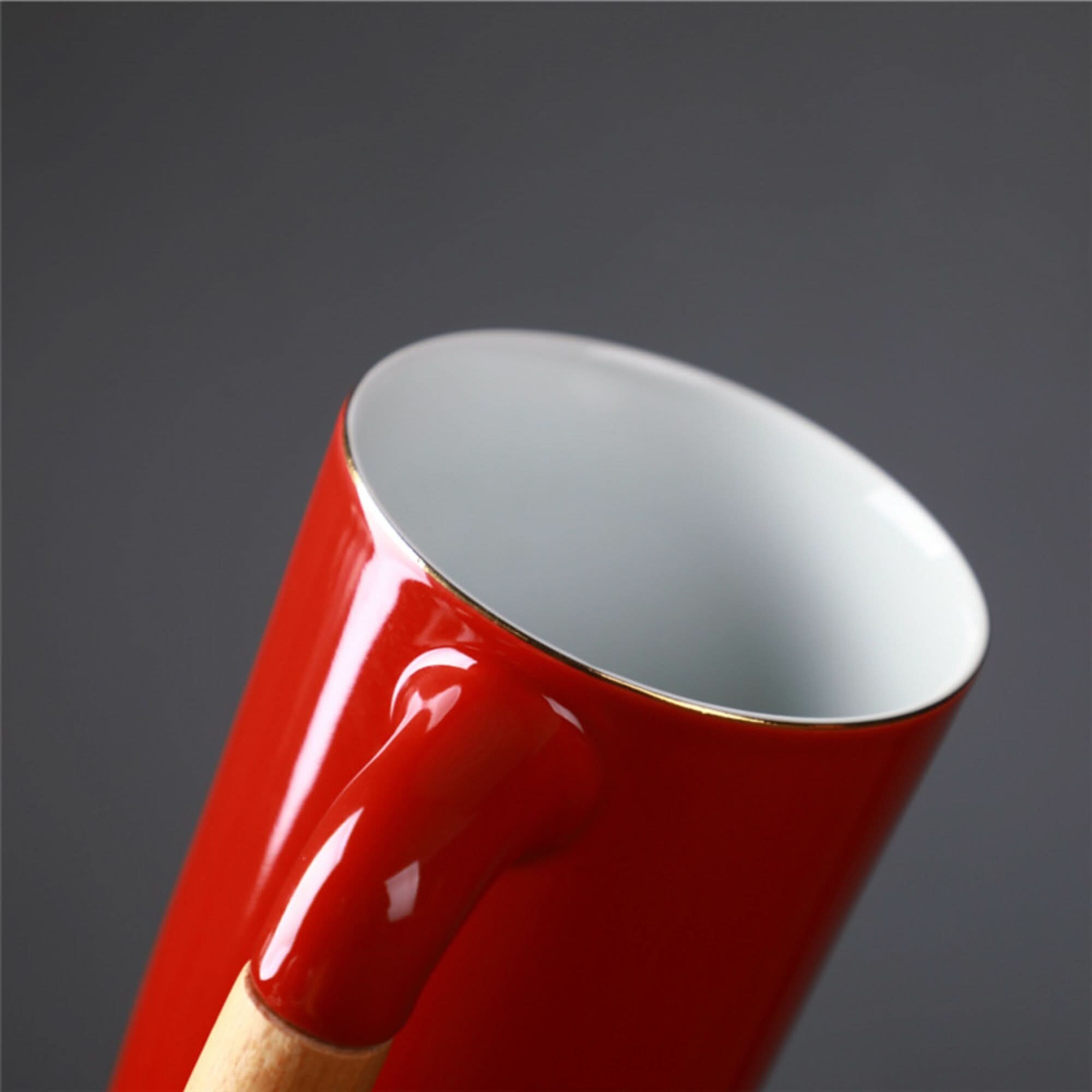 Red ceramic Japanese Mug 2x1 with wooden handle and gold rim, on a dark background.