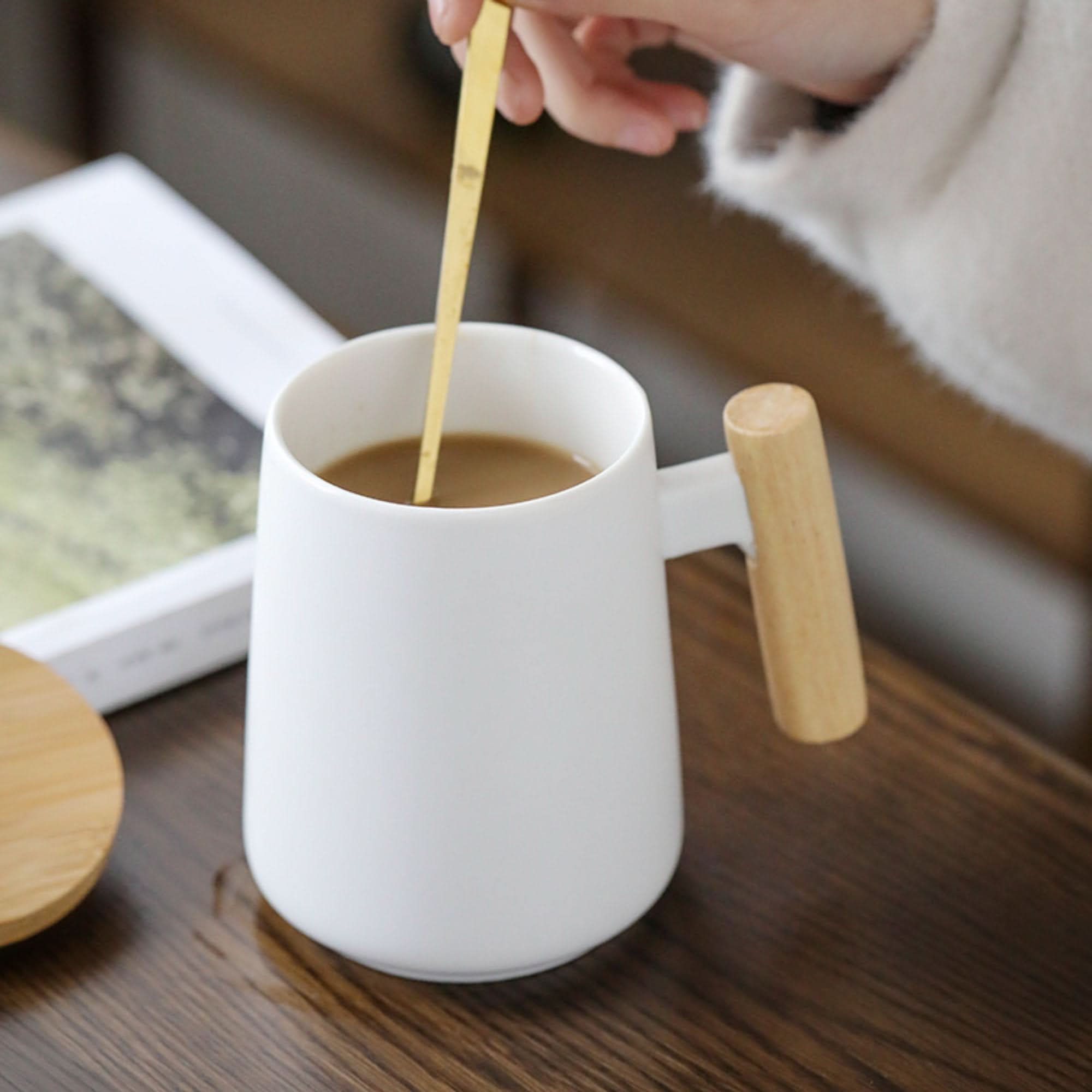 Minimalist Japanese Mug 480ml with wood handle, holding coffee.