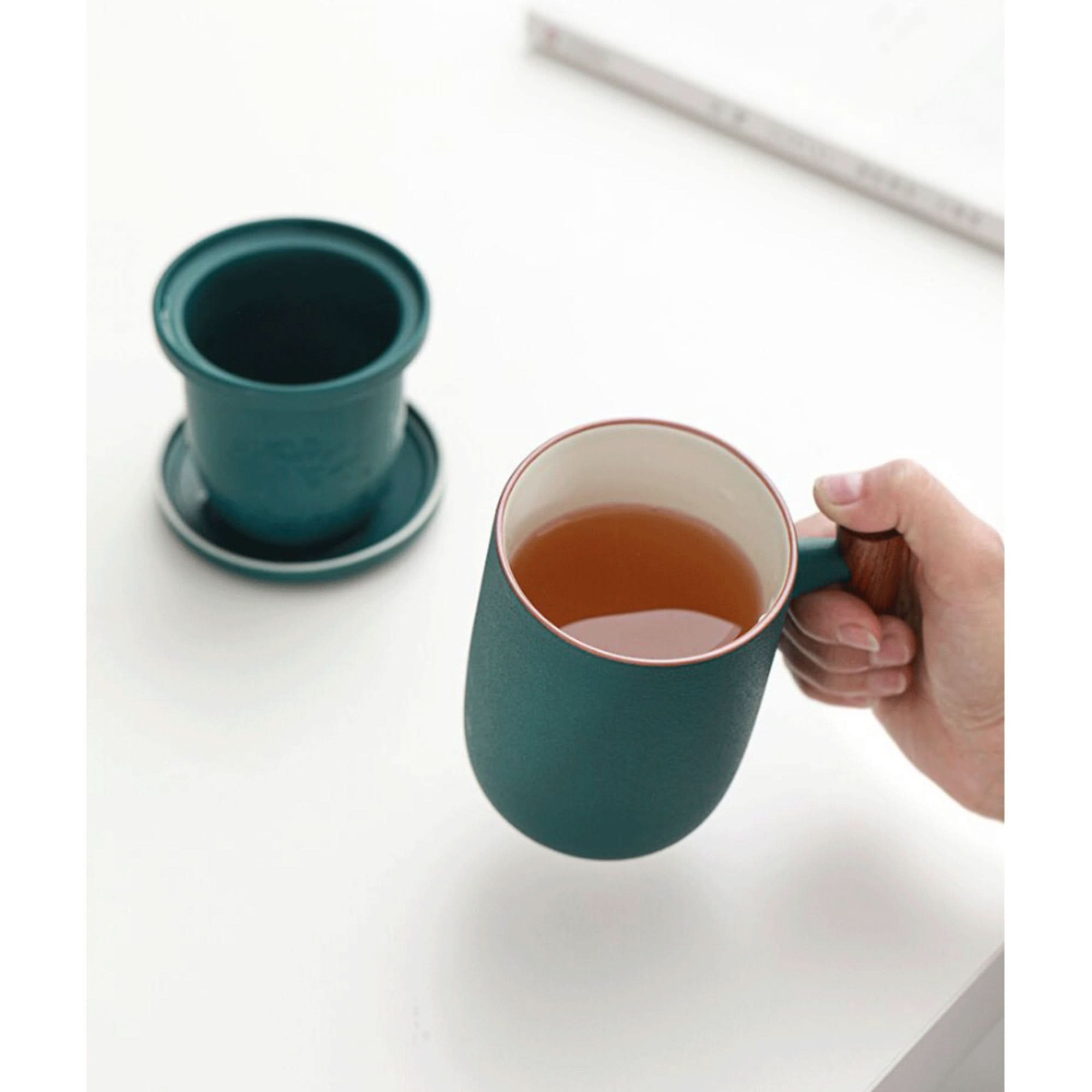 Dark teal Minimalist Japanese Mug 13.5oz, ceramic with wooden handle, filled with tea.