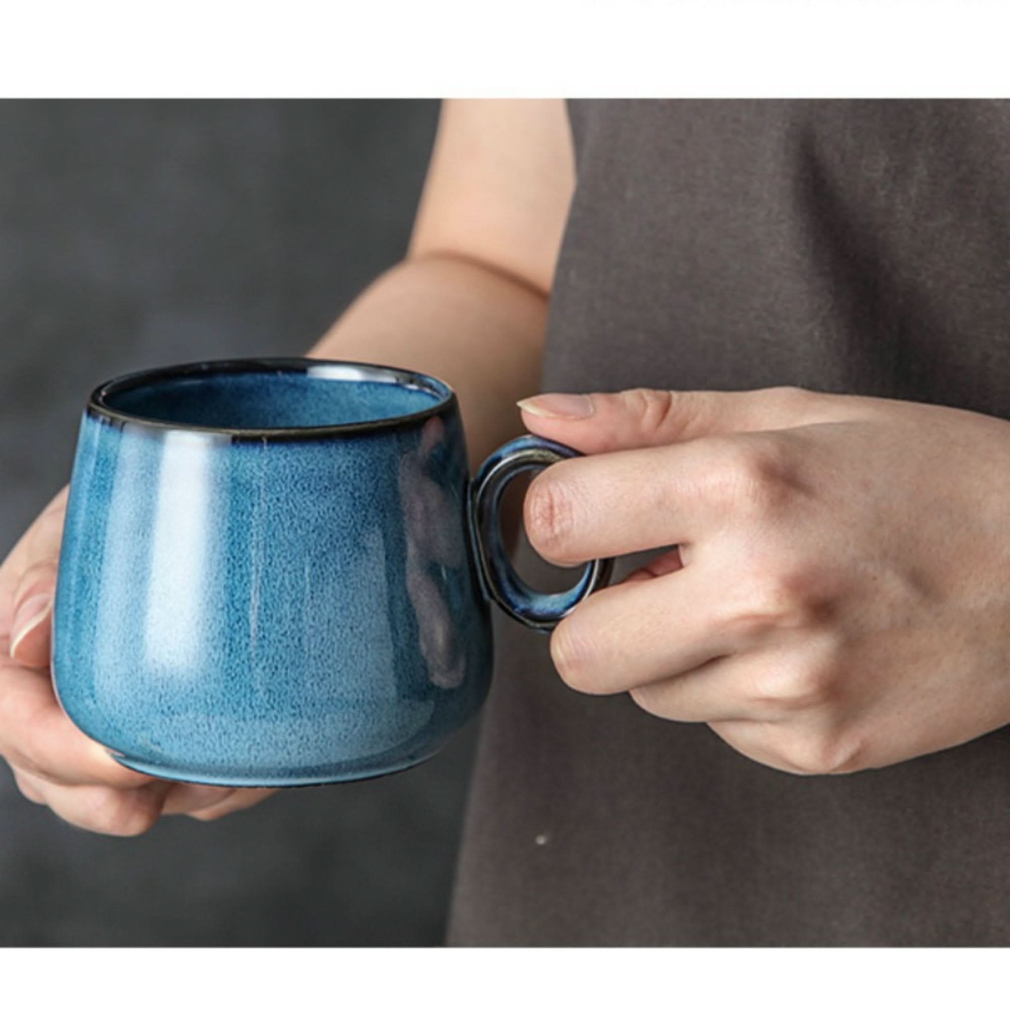 Blue stoneware Retro Mug 2 for 1 with rustic glaze and black rim, held by hands.