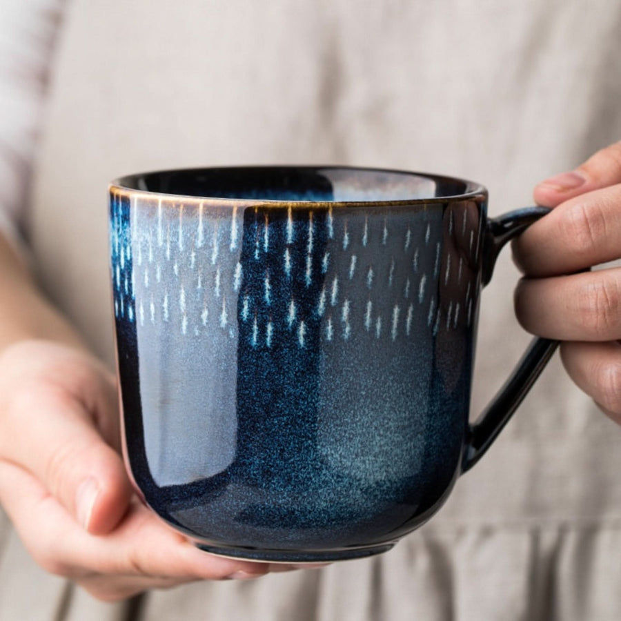 Ceramic mug with blue glaze and white lines, a stylish home decor piece.