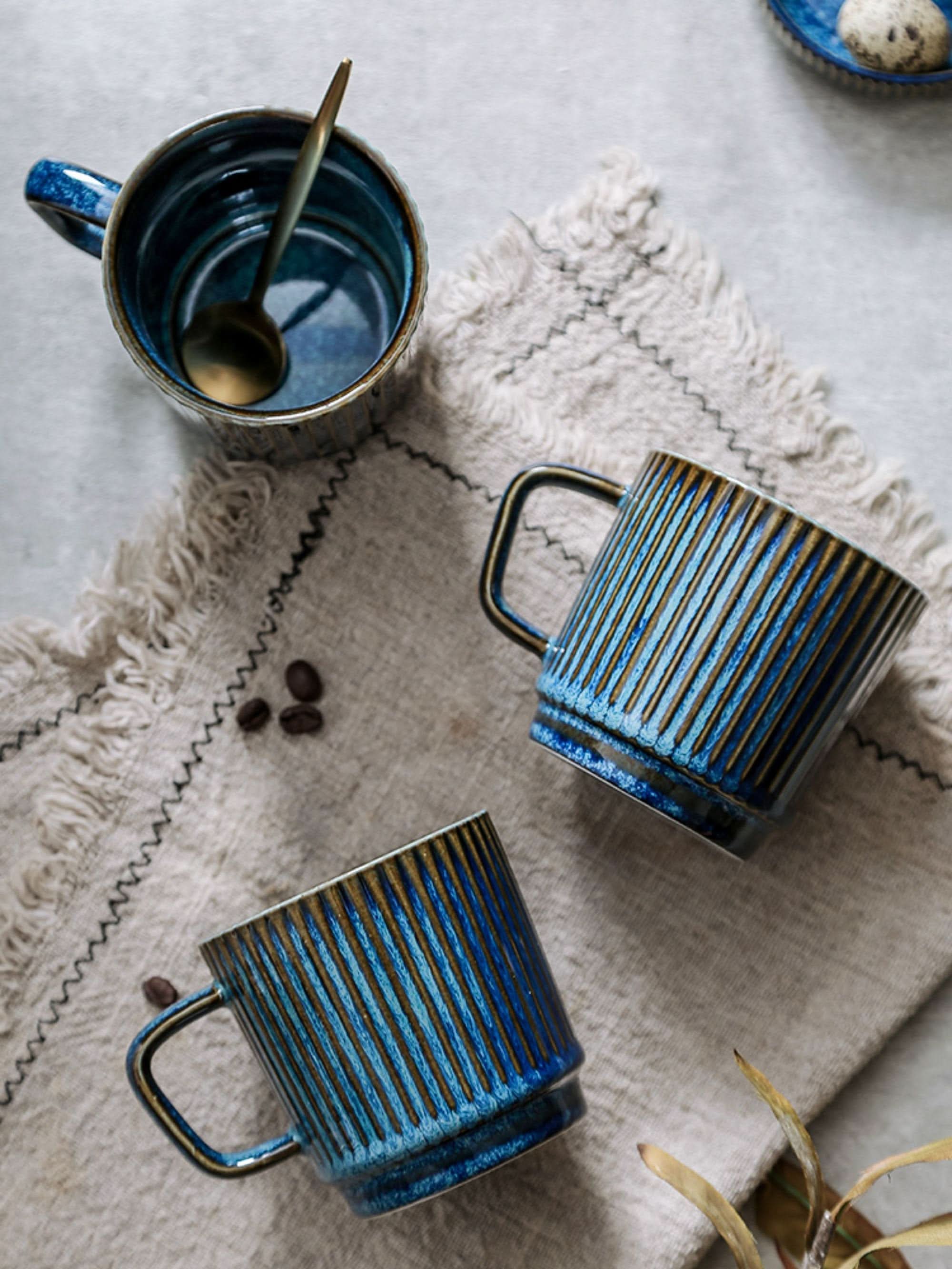Blue glazed ceramic travel mug with ribbed texture. Custom latte mug.