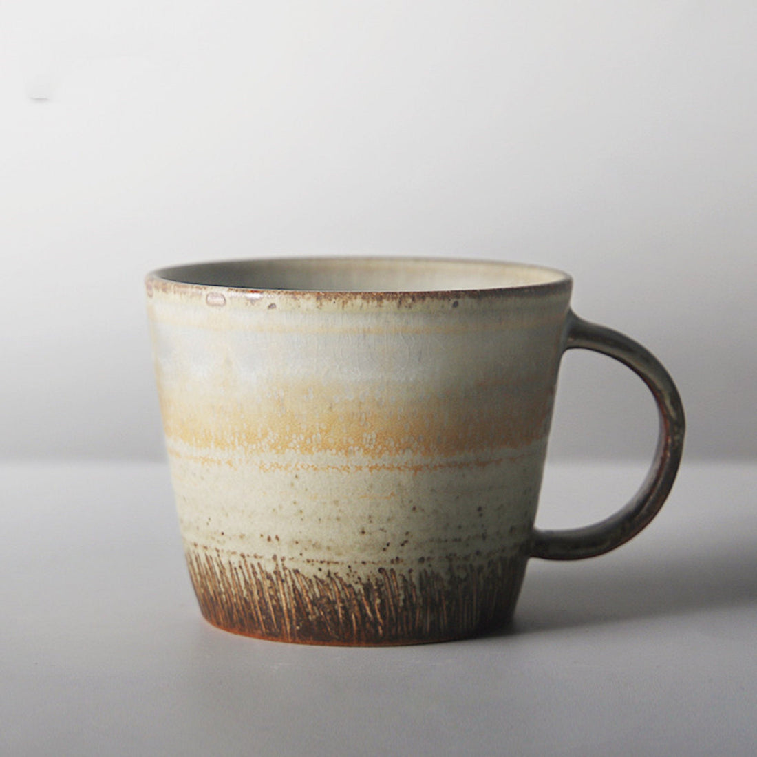 Japanese stoneware mug, multi-colored, unique design, handle.