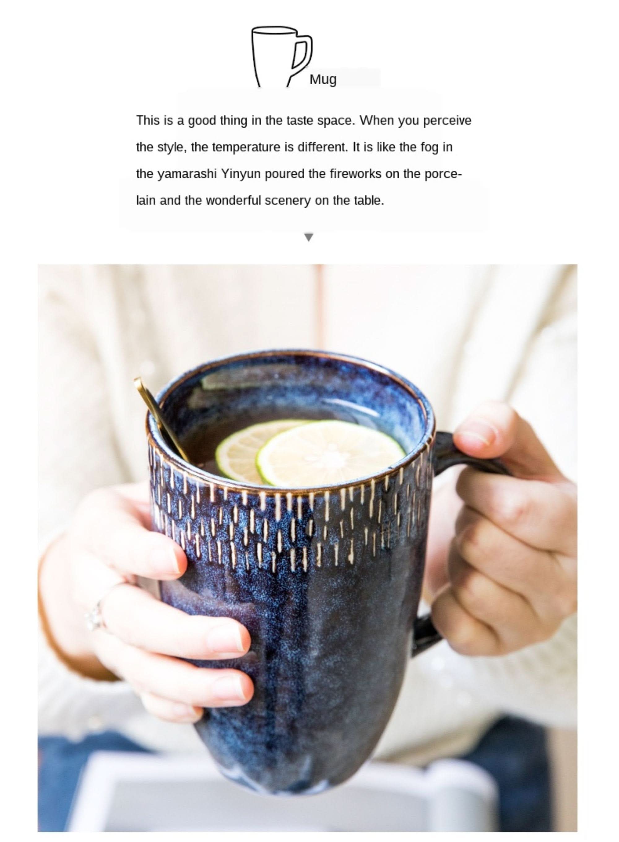 Dark blue glazed stoneware mug with textured pattern, holding beverage with lime slices.