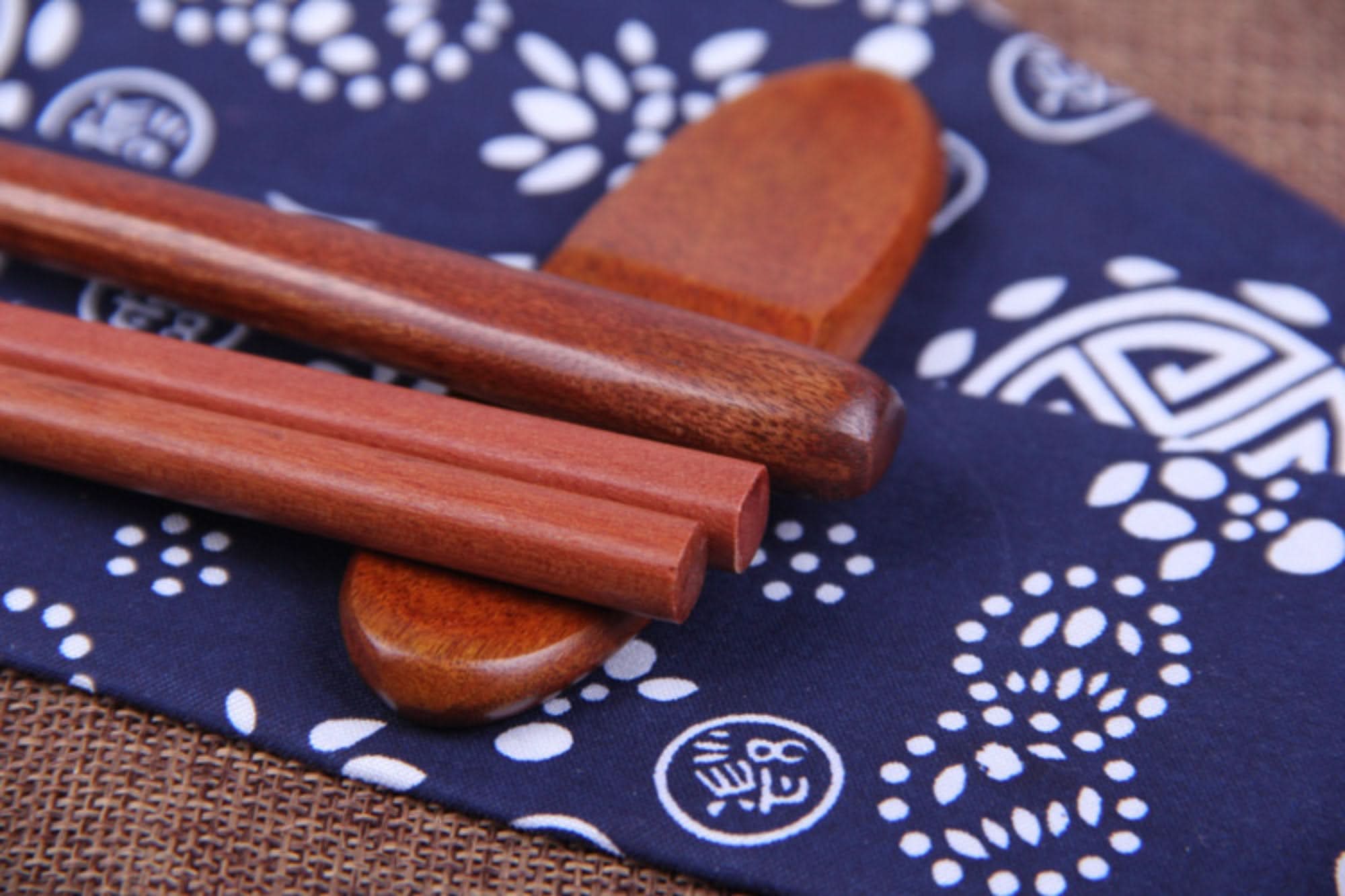 Japanese wood cooking utensils and spoon set on blue patterned fabric case.