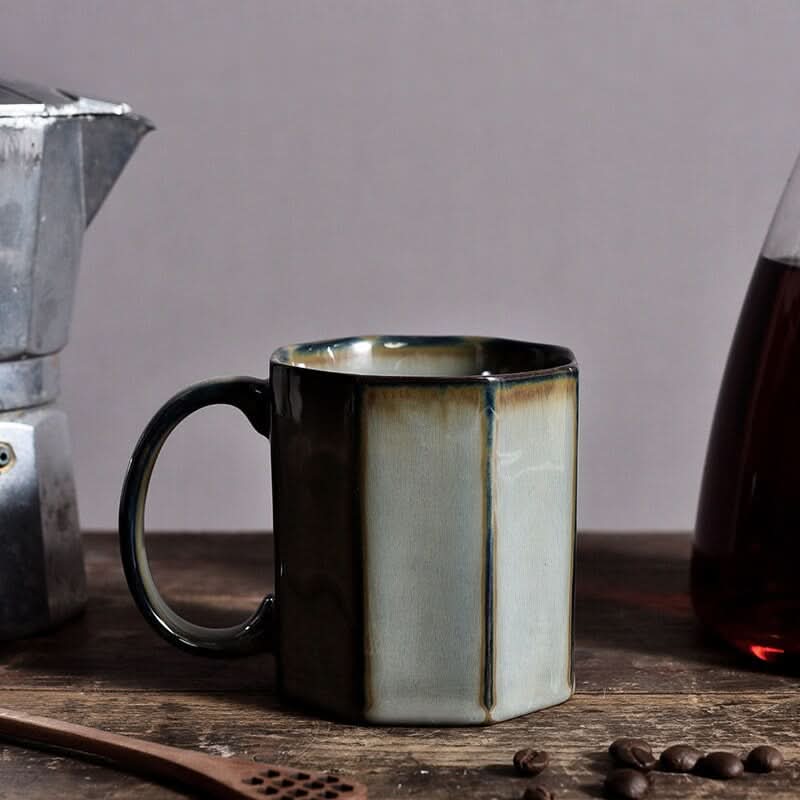 Nordic Rustic Hexagonal Ceramic Mugs in muted green and brown glaze, styled with coffee beans and a moka pot.