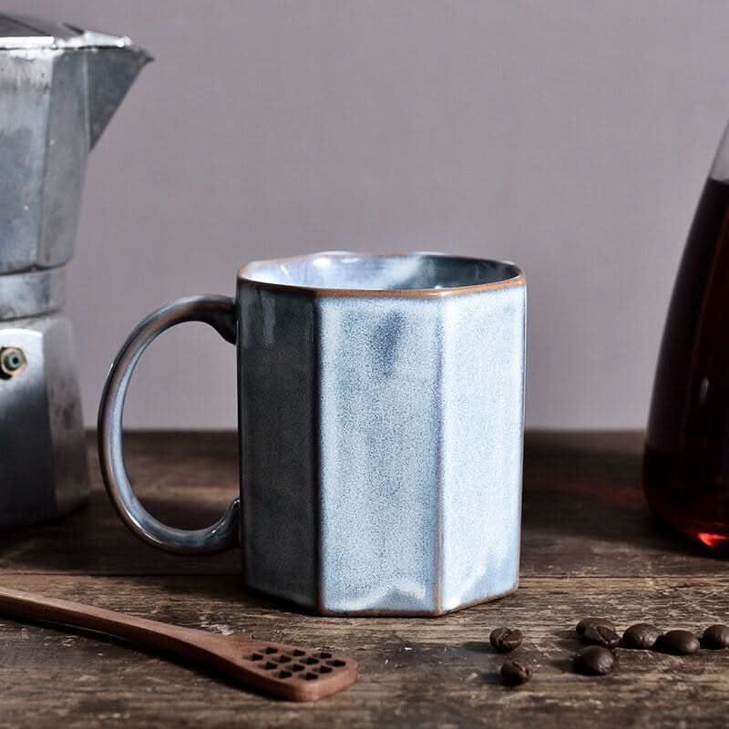 Nordic Rustic Hexagonal Ceramic Mug in light blue, styled with coffee beans and a wooden spoon.