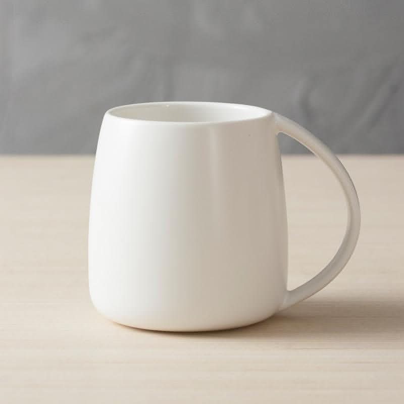 White Nordic Ceramic Mug with minimalist design on wooden surface.