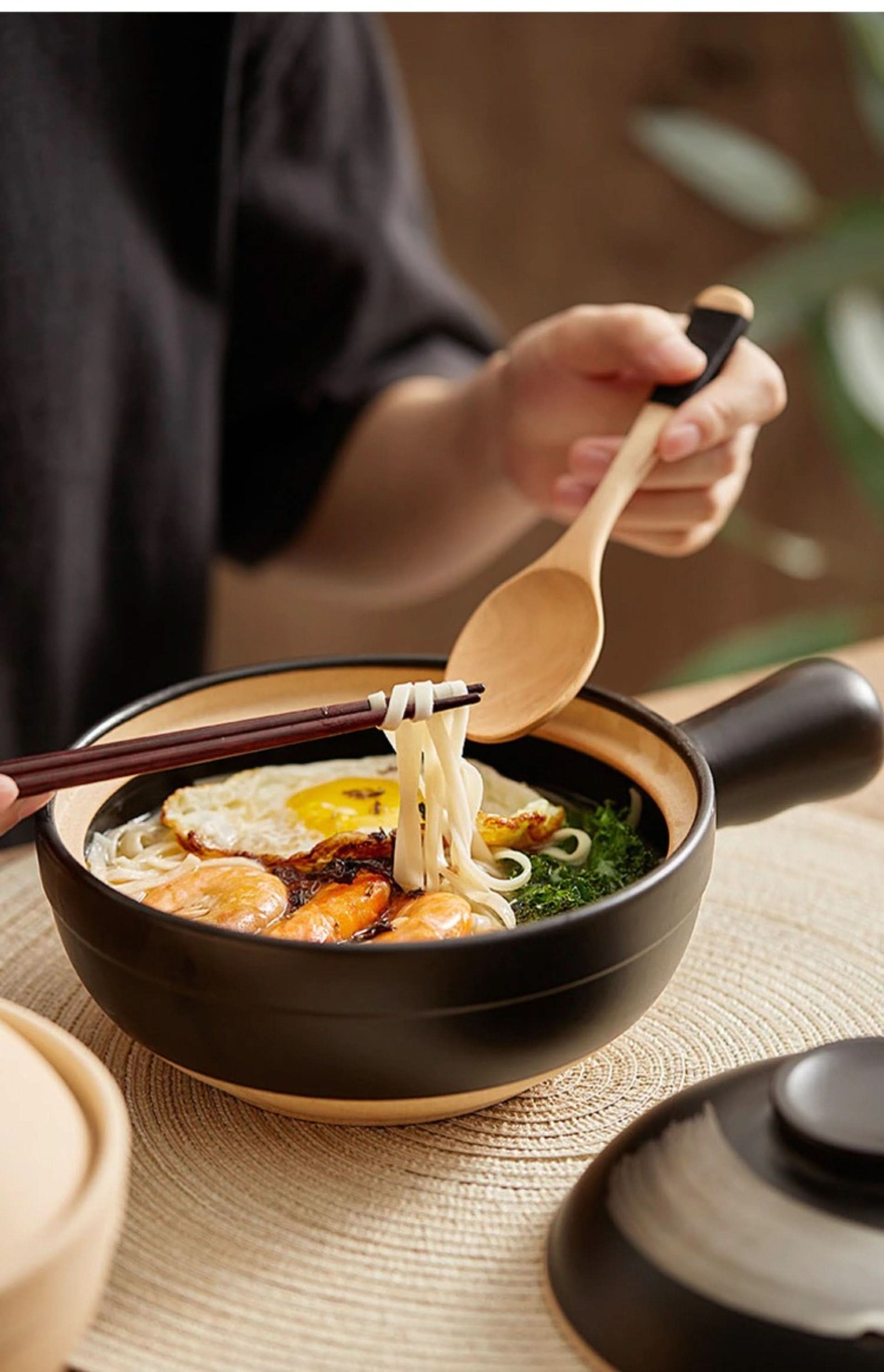 Rustic unglazed stoneware baking plate with Asian noodles, shrimp, and egg.