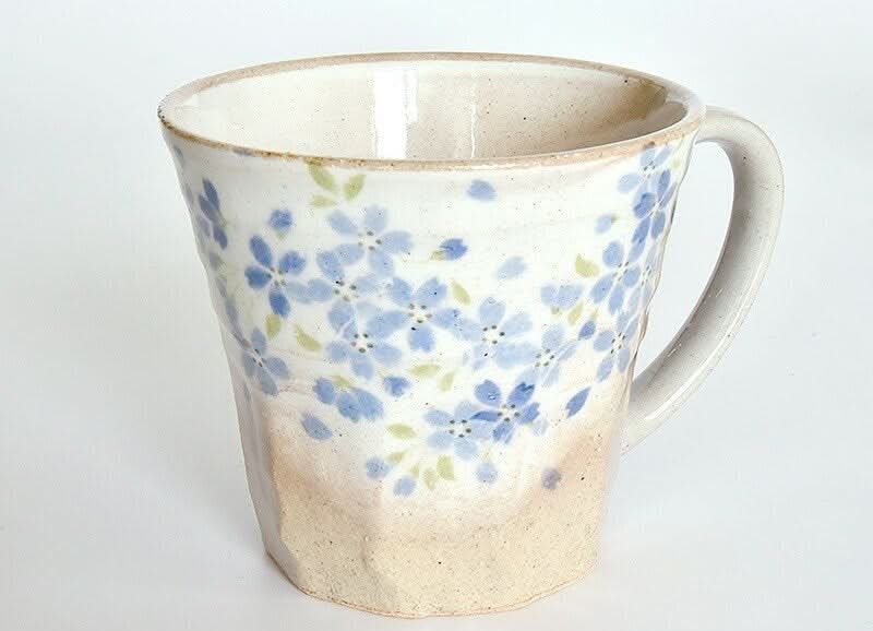 Handmade Japanese stoneware tea cup with blue floral glaze.