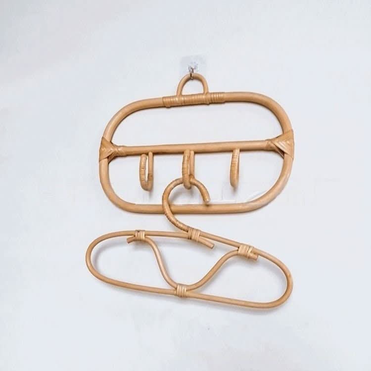 Natural rattan wall hanging hook and coat hangers on a white wall. Home decor.