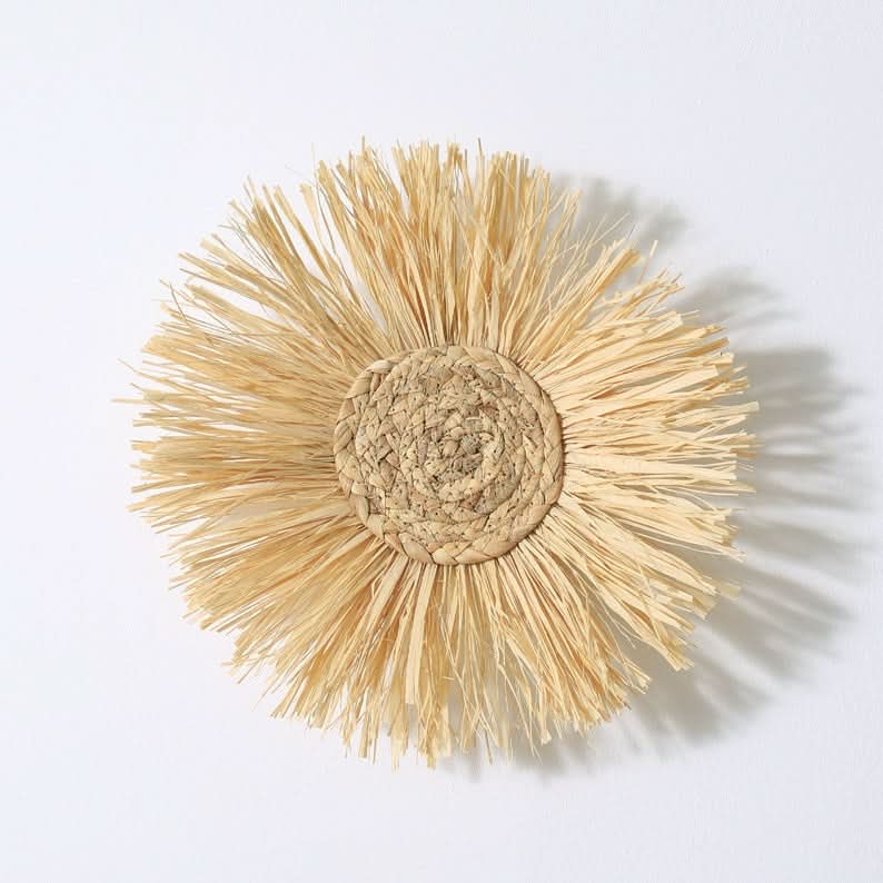 Natural straw Rattan Wall Basket with boho fringe on white background.
