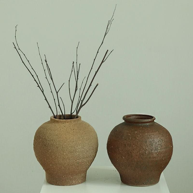 Wabi-Sabi rustic vases: tan and brown textured ceramic, rounded shape, tight top, with dried branches.