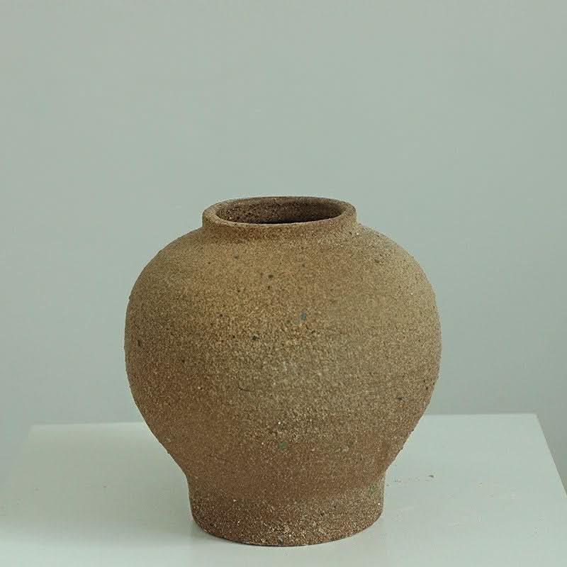 Rustic brown Wabi-Sabi vase with rounded shape and tight top, neutral background.