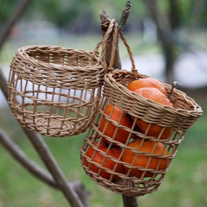 Wicker kitchen wall hanging basket with oranges, natural woven texture, perfect for fruit storage.