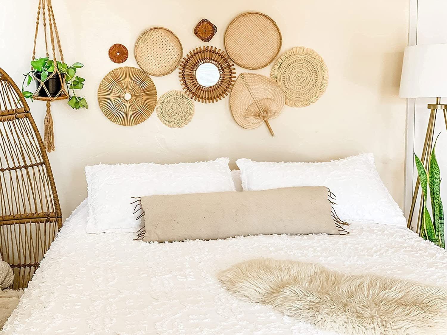 Handmade Straw Boho Wall Decoration collection on a wall above a white bed.
