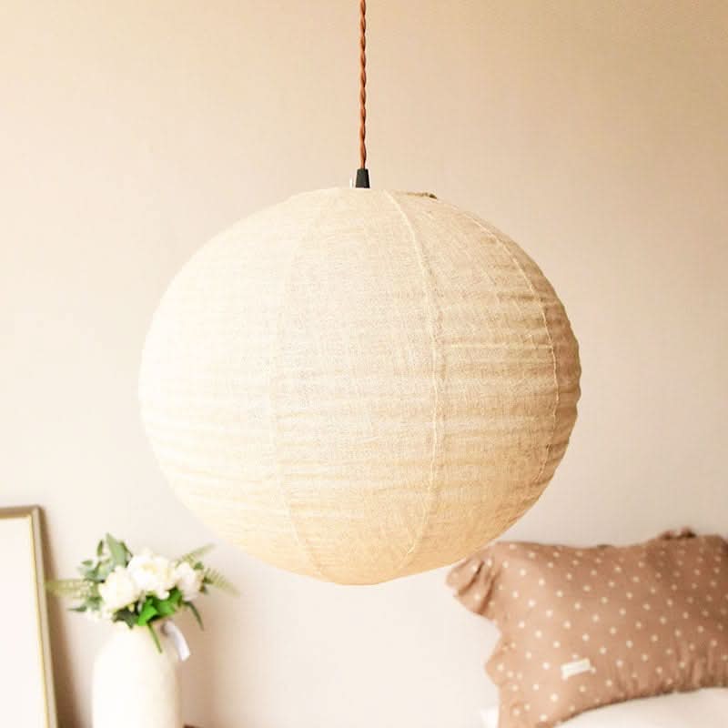 Natural linen ceiling shade, round shape, hanging in a room with decor.