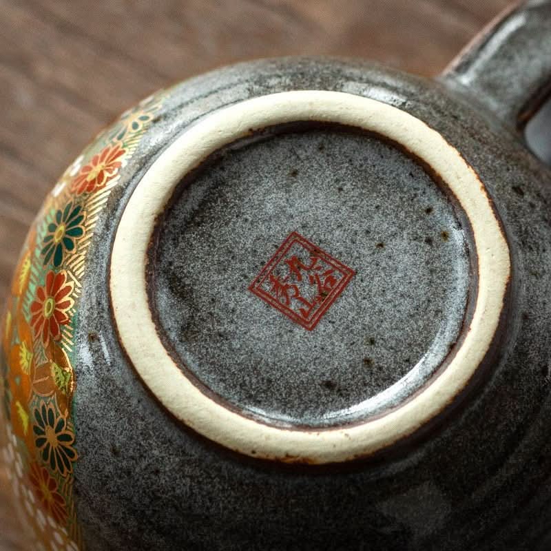Kutani-yaki stoneware mug detail: floral band, red artist stamp, speckled grey glaze.