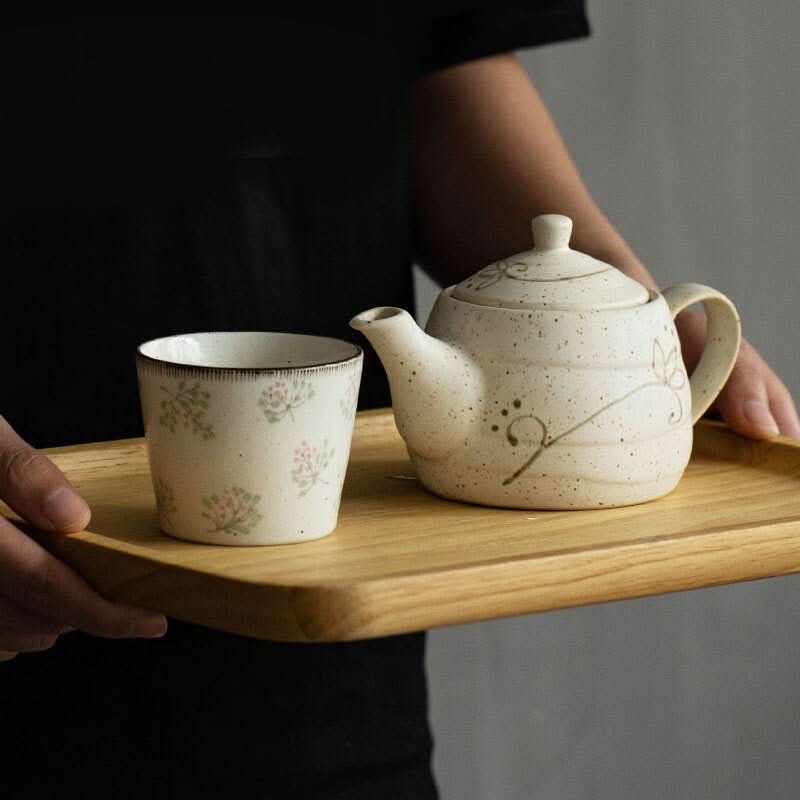 White Japanese Mino-yaki ceramic cup with floral design, 6.76oz, on wooden tray.