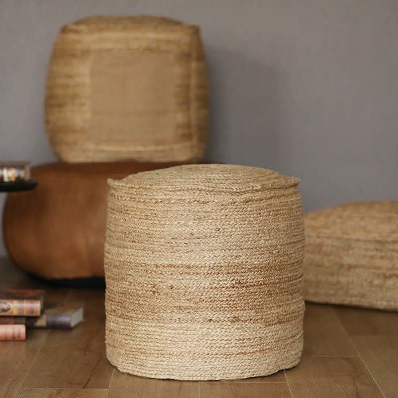 Indian Hand-Woven Natural Jute Ottoman, textured beige round pouf on wooden floor.
