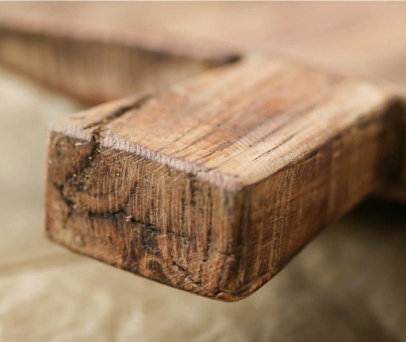 Close-up of textured brown wood grain on an irregular rectangular wooden serving tray.