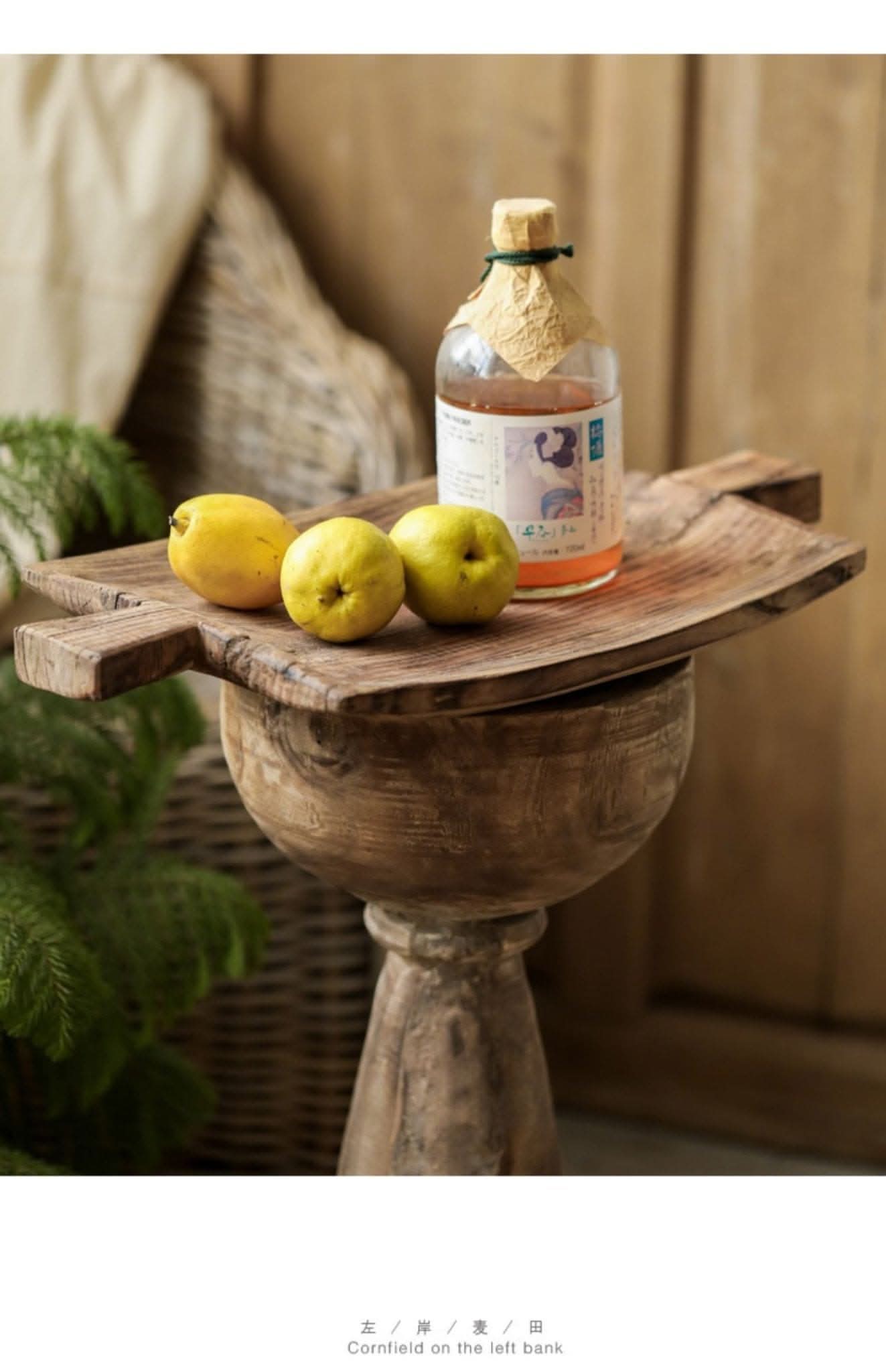 Rustic irregular rectangular wooden serving tray with lemons and bottle on pedestal