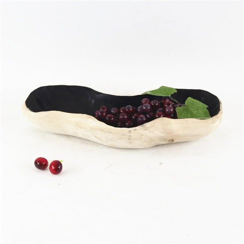 Organic wood bowl for fruit with grapes and leaves on white background.