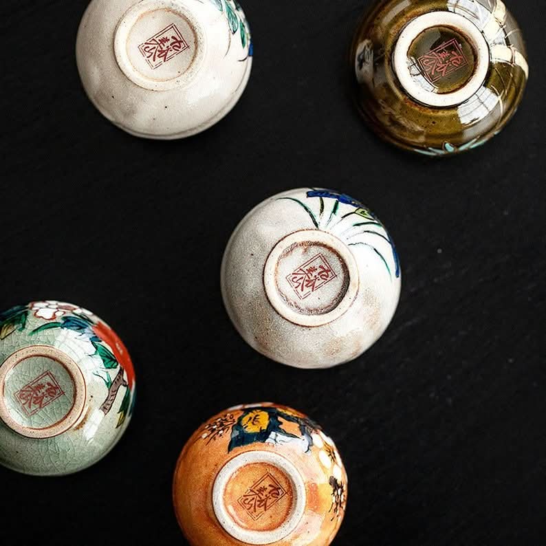 Five-Herb Flower Tea Cup Set, artisanal ceramic cups with floral designs, top view.