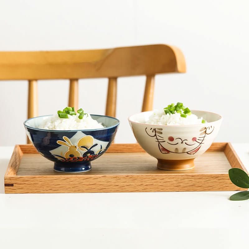 Japanese bowls with rabbit & cat illustrations, filled with rice. Home decor.
