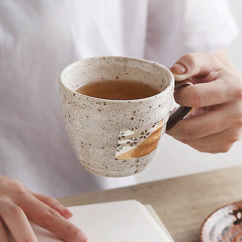 Japan Imported Foil Mug One Gold Pair Cup with floral pattern, holding tea.