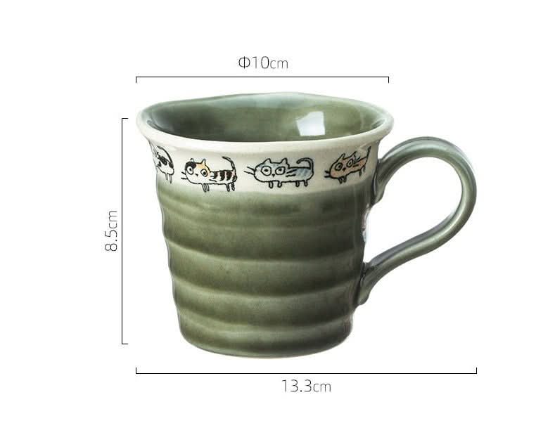 Japan imported handmade screw shaped cat mug, green stoneware with playful cat illustrations.