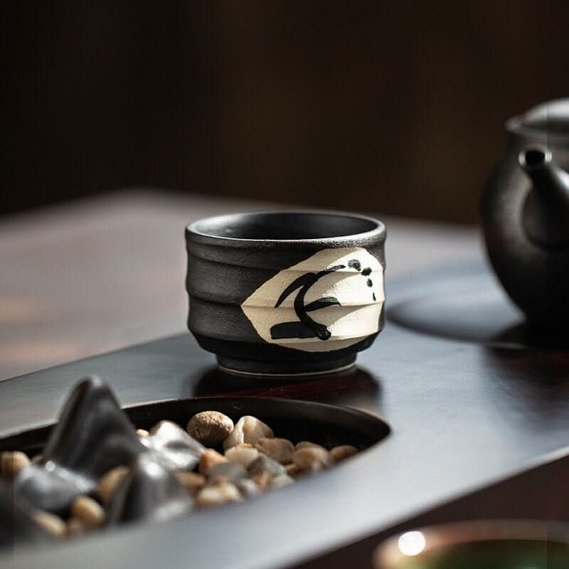 Japan Imported Mino-Yaki Night Breeze Tea Cup: Simple black ceramic cup with white abstract design.