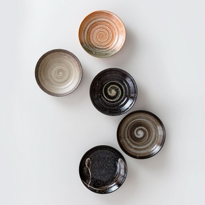 Japan-imported Mino yaki ceramic deep dishes with underglaze swirl patterns in earthy tones.