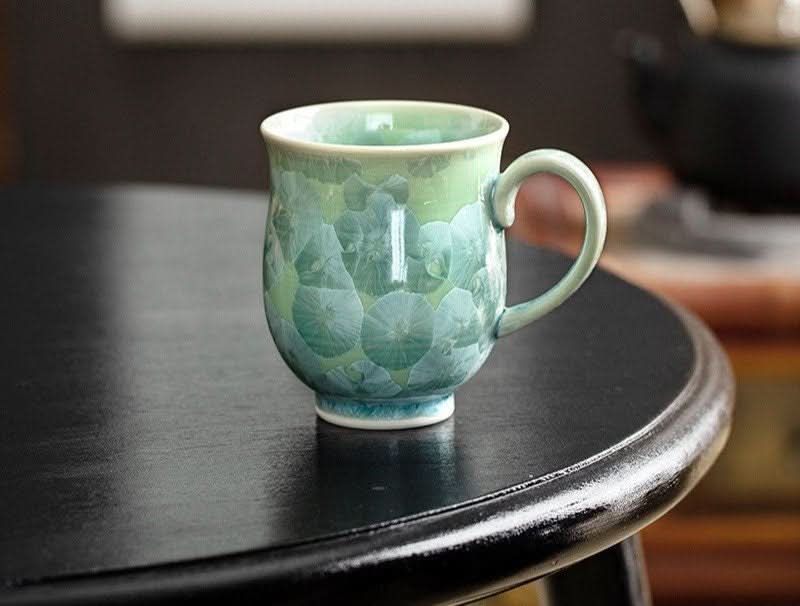 Japan Imported Pottery Mug with clear water burning crystal glaze, green floral pattern on ceramic.