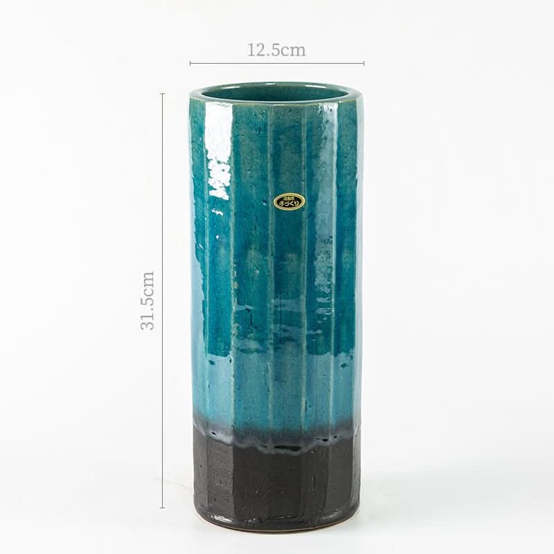 Tall Shigaraki ceramic flower arrangement, blue-green glaze, black base.