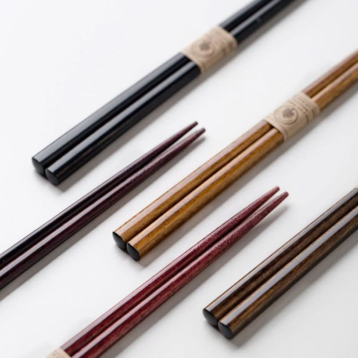 Five pairs of natural wood chopsticks in black, brown, and red.  Stylish, non-slip design.