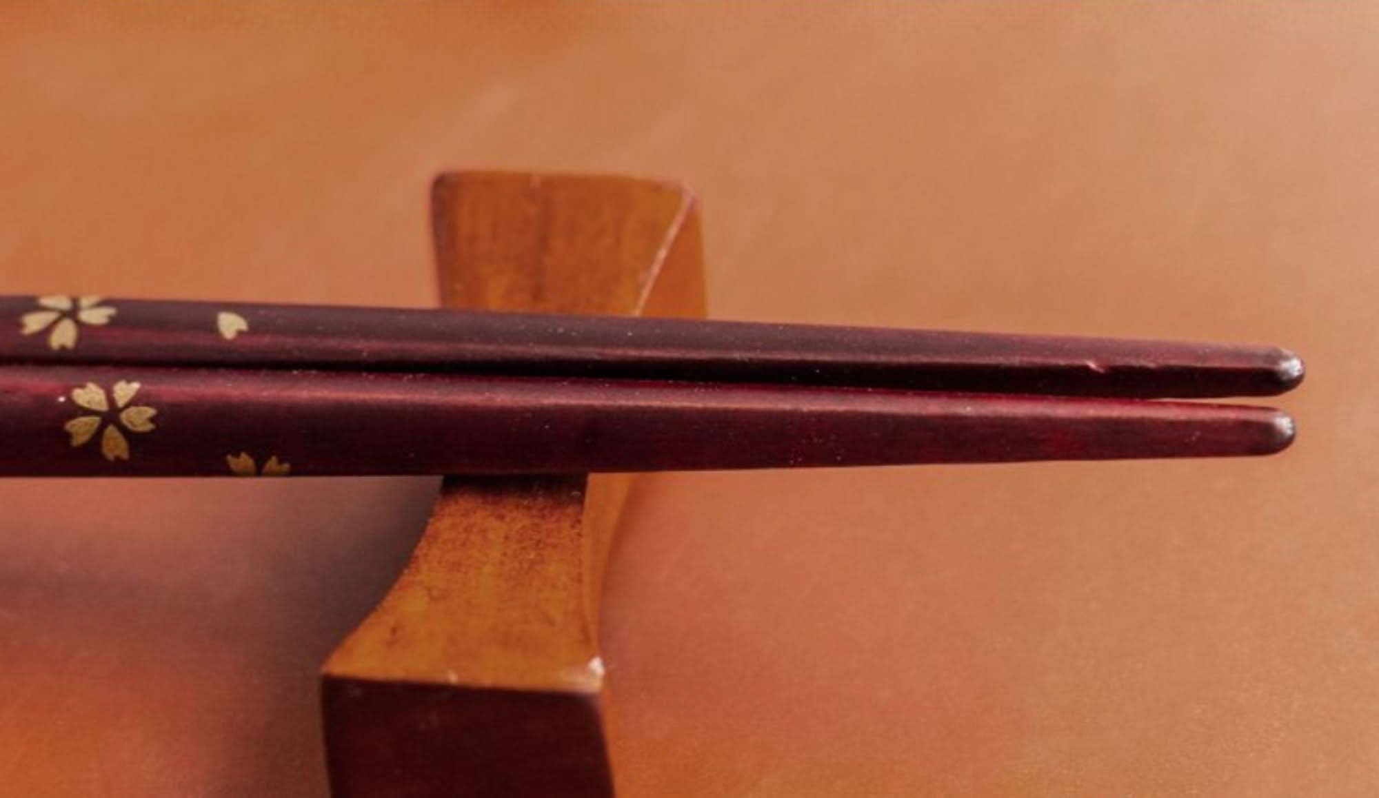 Japan Imported Sunlife Handmade Cherry Chopsticks, solid wood, gold flower detail, on wooden rest.