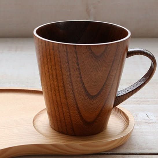 Japan imported traditional lacquered chestnut wood mug on light wood saucer.