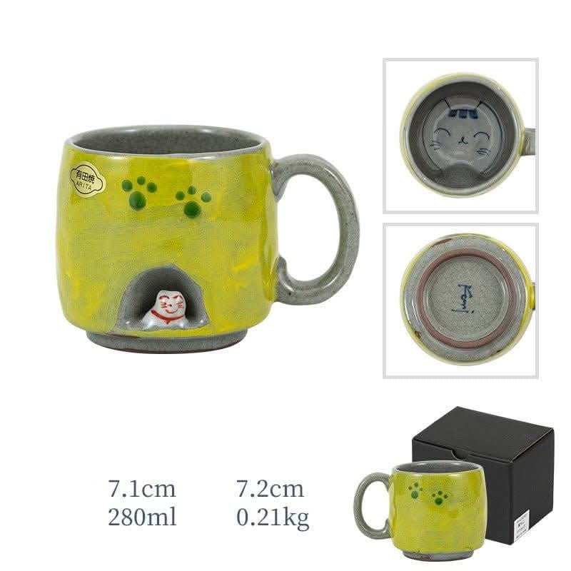 Yellow Arita ware hand-made cat mug with paw prints and a hidden cat figurine. Home decor accent.