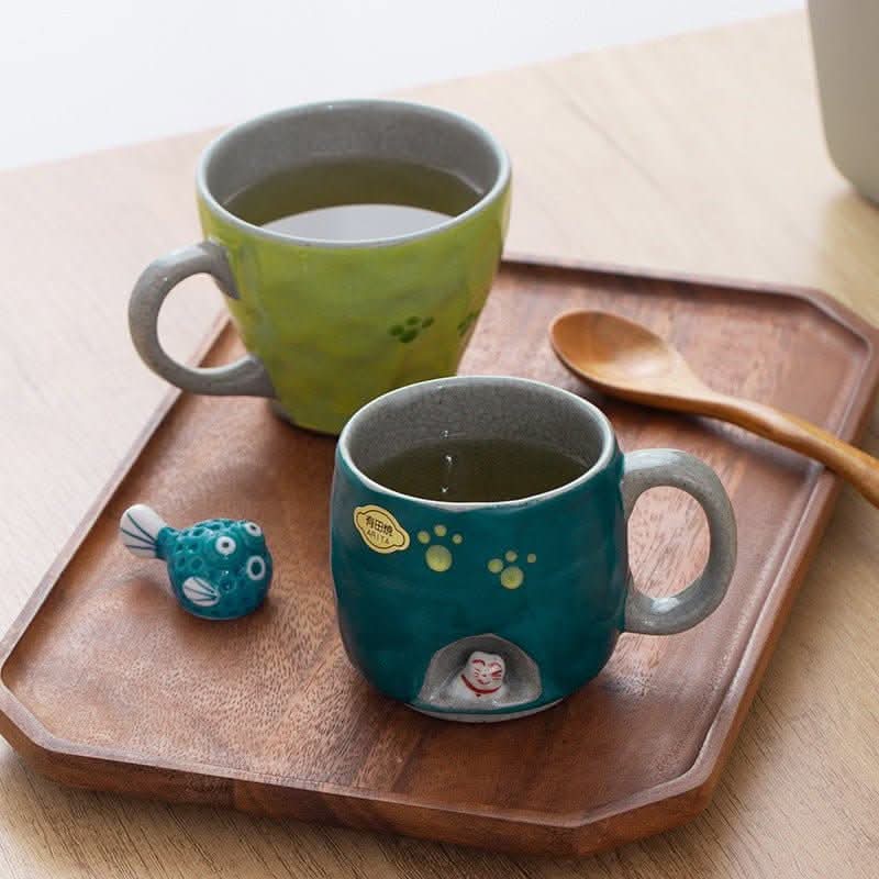Handmade Arita ware cat mug, teal ceramic, paw prints, with fish charm & spoon.