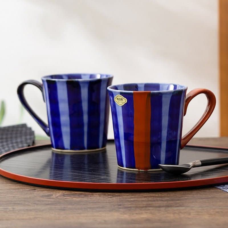 Japan imports Arita ware hand-painted blue striped mug with orange accent.